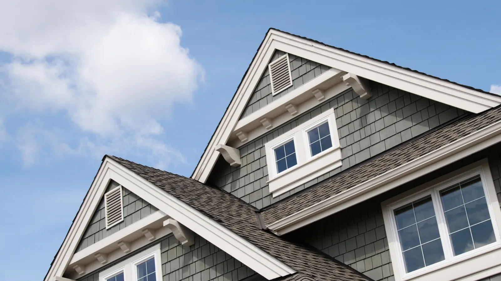 House gables with white trim above a brown shingle roof