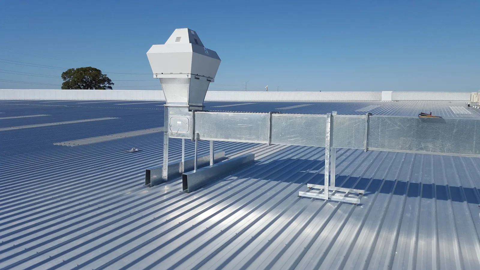 Rooftop vent and ductwork on a corrugated metal commercial roof